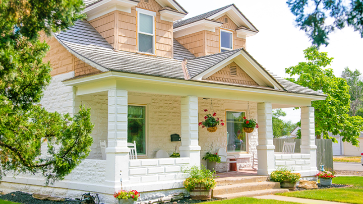 A white and tan American Craftsman style house on a sunny day. 